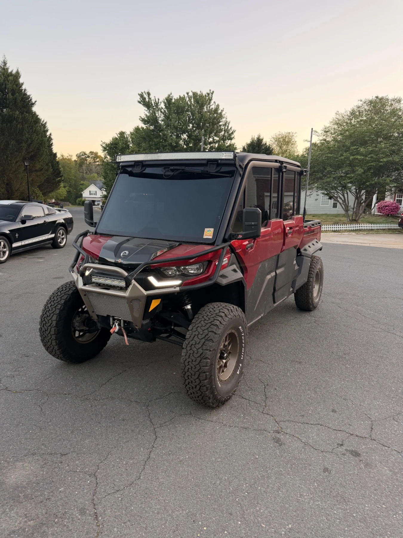 Custom red and black Can-Am Defender with tinted windshield and off-road lighting